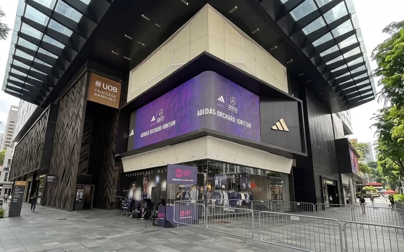 LED screen on the corner of a flagship store on Orchard Road, Singapore, showing the event branding for the live production