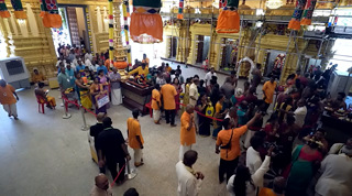 Devotees and temple volunteers gathered inside the main hall of Sree Maha Mariamman Temple, Singapore, seen from above