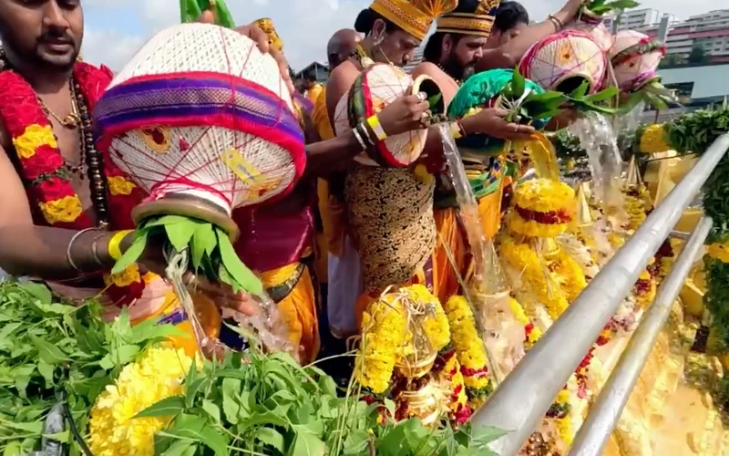 Priests pour sacred water from decorated kalasam pots at the Sree Maha Mariamman Temple Maha Kumbhabishegam